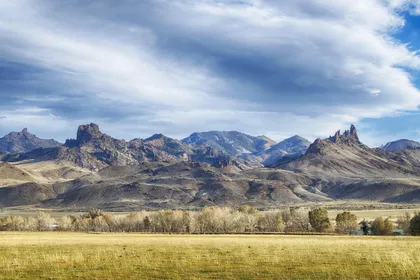 Open Wyoming ranchland under a wide sky, dry grass running to low hills